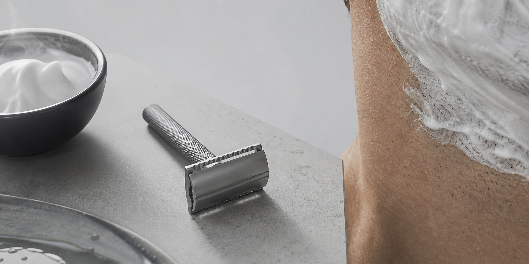 Shaving foam, razor detail, and cropped male skin texture